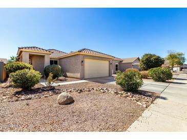 Charming home with a desert landscaped front yard with a two car garage at 36579 W Barcelona Ln, Maricopa, AZ 85138