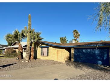 Charming single-story home with a desert landscaped yard, and blue garage door at 3810 W Belmont Ave, Phoenix, AZ 85051