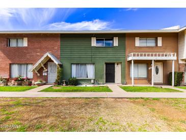 Three townhomes featuring individual entrances, unique paint colors and lovely green lawns at 6615 N 44Th Ave, Glendale, AZ 85301