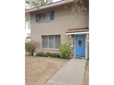 Charming two-story brick home with a blue front door and well maintained front yard at 1652 W Campbell Ave, Phoenix, AZ 85015