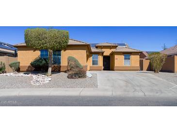 Charming single-story home with desert landscaping and a covered entrance on a sunny day at 25564 W Magnolia St, Buckeye, AZ 85326