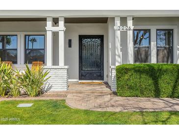Elegant front entrance features a beautiful iron gate door and manicured landscaping at 3226 E Sells Dr, Phoenix, AZ 85018