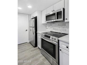 Modern kitchen features stainless steel appliances, white cabinets, and a stylish backsplash at 600 S Dobson Rd # 175, Mesa, AZ 85202
