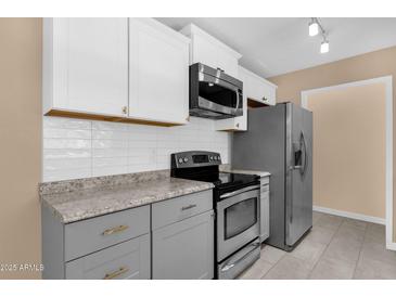 Well-equipped kitchen featuring stainless steel appliances, light countertops, and a modern backsplash at 623 W Guadalupe Rd # 131, Mesa, AZ 85210