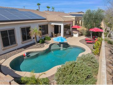 Aerial view of backyard pool with desert landscaping, patio, outdoor kitchen, and solar panels at 12873 N 175Th Dr, Surprise, AZ 85388