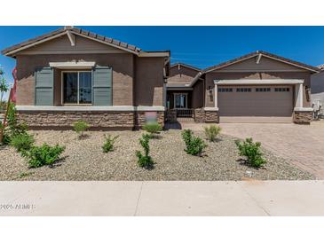 Charming single-story home featuring a two-car garage, desert landscaping, and a welcoming entrance at 20624 S 216Th Pl, Queen Creek, AZ 85142