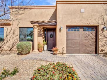 Stunning front exterior with meticulous landscaping, a decorative wreath on the front door, and a convenient attached garage at 4241 N Pebble Creek Pkwy # 42, Goodyear, AZ 85395