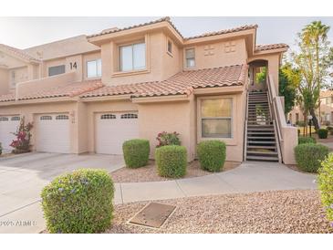 Charming townhome exterior featuring a private garage, landscaped front yard, and inviting staircase to the entrance at 5450 E Mclellan Rd # G227, Mesa, AZ 85205