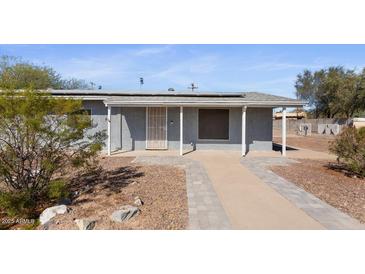 Charming home with a stucco facade, solar panels, and desert landscaping at 606 E Baseline Rd, Buckeye, AZ 85326