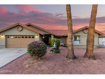 Charming home featuring desert landscaping, tile roof, and a two car garage at 9014 E Sharon Dr, Scottsdale, AZ 85260