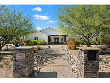 Charming home exterior features a well-manicured front yard, desert landscaping and inviting walkway to the front door at 11212 N Miller Rd, Scottsdale, AZ 85260