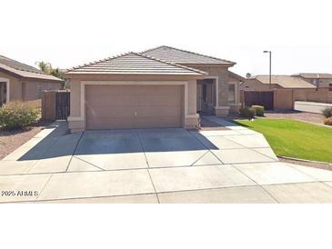 Charming single-story home with a well-maintained front yard and a spacious two-car garage at 13547 W Peck Dr, Litchfield Park, AZ 85340