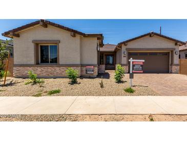 Charming single-story home with desert landscaping, a brick driveway, and a two-car garage at 20570 S 216Th Pl, Queen Creek, AZ 85142