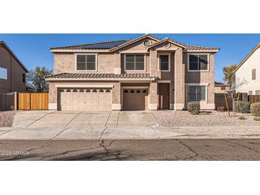 Two-story home featuring a driveway, a two-car garage, and solar panels on the roof at 3124 W Redbird Rd, Phoenix, AZ 85083