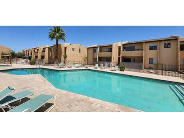 Large community pool with lounge seating on a sunny day at 8055 E Thomas Rd # A102, Scottsdale, AZ 85251