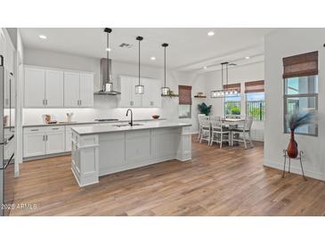 Open-concept kitchen with a central island, stainless steel appliances, and dining area at 11241 N Blakely St, Surprise, AZ 85388