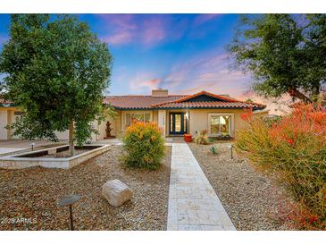 Beautiful single-story home featuring low maintenance desert landscaping and walkway leading to the front door at 12448 N 76Th St, Scottsdale, AZ 85260