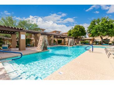 Stunning community pool area features waterfalls, lounge chairs, and meticulously maintained landscaping at 20100 N 78Th Pl # 2210, Scottsdale, AZ 85255