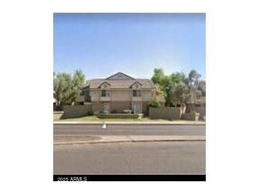 Inviting two-story home featuring a well-maintained lawn, mature trees, and a classic design at 2035 S Elm St # 114, Tempe, AZ 85282