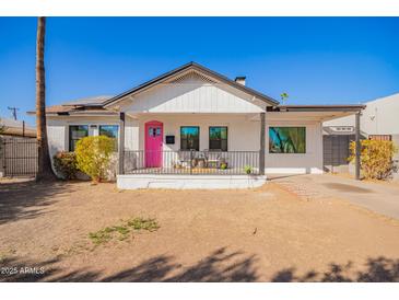 Charming single-Gathering home with freshly painted white exterior, a pink door, and inviting front porch at 2320 E Harvard St, Phoenix, AZ 85006