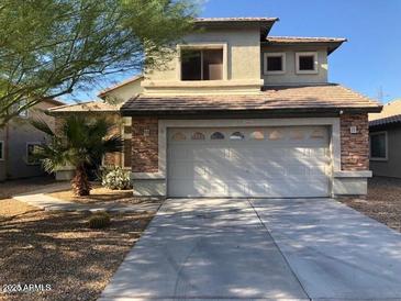 Charming two-story home featuring a well-manicured lawn, stone accents, and a two-car garage at 25532 W Williams W St, Buckeye, AZ 85326