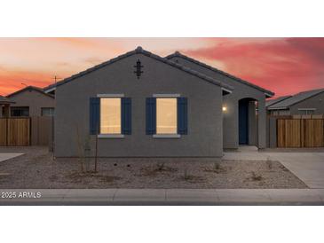 Charming single-story home featuring blue shutters and low-maintenance landscaping against a vibrant sunset backdrop at 2673 E San Miguel Dr, Casa Grande, AZ 85194