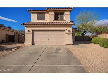 A charming two-story home features a two-car garage, desert landscaping, and a tile roof against a bright blue sky at 3621 W Keller Ct, Anthem, AZ 85086