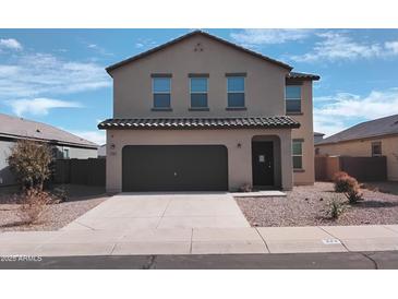 A modern two-story home with a dark garage door and desert landscaping at 374 S Verdad Ln, Casa Grande, AZ 85194