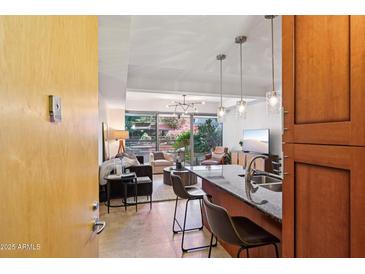 Open-concept living room with island seating and sliding glass doors to the outside at 7131 E Rancho Vista Dr # 4003, Scottsdale, AZ 85251