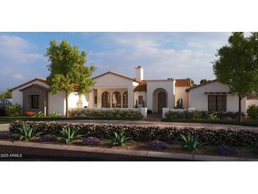 Elegant stucco home featuring an arched entryway, terracotta roof, and vibrant landscaping at Xxx N 158Th Ave, Surprise, AZ 85387