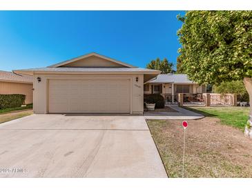 Charming home featuring a two-car garage, well-kept lawn, and inviting curb appeal at 10439 W Saratoga Cir, Sun City, AZ 85351