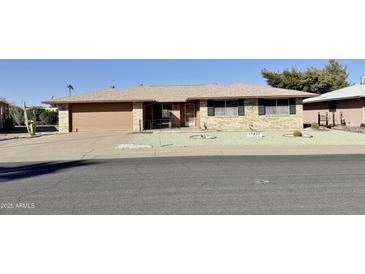 Charming single-story home with a well-manicured front yard and a two-car garage at 10450 W Sutters Gold Ln, Sun City, AZ 85351