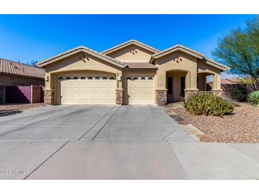 Charming single-story home featuring a three-car garage and desert landscaping under a bright blue sky at 1412 E Jade Dr, Chandler, AZ 85286