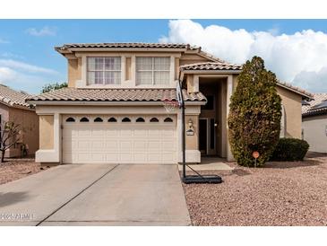 Two-story home featuring a neutral color scheme, two-car garage, tile roof, and well-maintained desert landscaping at 15618 N 12Th Ave, Phoenix, AZ 85023