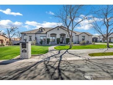 Stunning single-story home showcasing lush landscaping, brick accents, and a charming paver driveway at 20125 E Melissa Pl, Queen Creek, AZ 85142