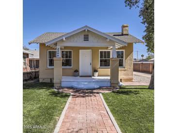 Charming bungalow with a brick walkway, freshly cut green grass, and cozy front porch at 2209 N 8Th St, Phoenix, AZ 85006