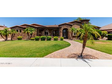 Beautiful desert landscaping graces the front yard with lush green lawn providing curb appeal at 3464 E Dartmouth St, Mesa, AZ 85213