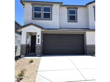 Charming two-story home featuring a 2-car garage, covered entry, and a mix of stone and stucco exterior at 9831 S 11Th St, Phoenix, AZ 85042