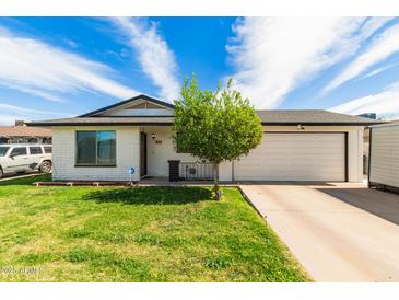 Charming single-story home with a well-manicured front lawn and a quaint shade tree at 113 N Ridge Cir, Mesa, AZ 85203