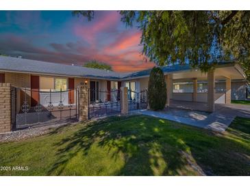 Charming home featuring a quaint gated courtyard and a convenient covered carport at 14006 N Tumblebrook Way, Sun City, AZ 85351