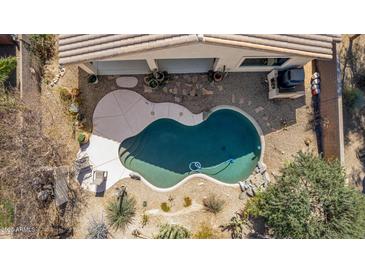 Aerial view of a private pool, with desert landscaping, and rock waterfall feature at 17560 W Desert View Ln, Goodyear, AZ 85338