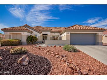 Charming home featuring a desert landscape, red rock and stone accents, tile roof and a gray two-car garage at 21402 N 158Th Dr, Sun City West, AZ 85375