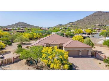 Stunning single-story home with a three-car garage surrounded by lush landscaping and mature trees at 2924 W Here To There Dr, Phoenix, AZ 85086