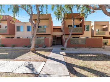 Contemporary apartment building with neutral colors, balconies, and well-maintained landscaping creates an inviting curb appeal at 3500 N Hayden Rd # 2109, Scottsdale, AZ 85251