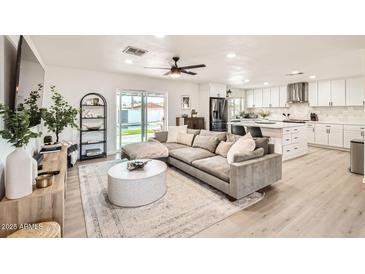 Spacious living room features a large sectional sofa, modern decor, and open access to the kitchen at 7333 E Palm Ln, Scottsdale, AZ 85257