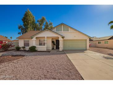 Charming single-story home featuring a two car garage and a desert landscaped front yard at 7737 W Cherry Hills Dr, Peoria, AZ 85345