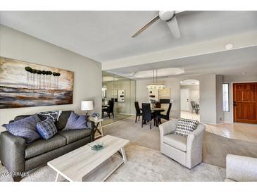 Inviting living room featuring modern decor, a ceiling fan, and neutral-toned walls for a bright, airy feel at 19035 N 83Rd Ln, Peoria, AZ 85382