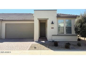 Inviting single-story home with a charming exterior and well-maintained landscaping and a two car garage at 357 E Las Puertas Ln, Queen Creek, AZ 85140