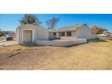 Charming single-story home featuring a low block wall, open carport, and desert landscaping for a welcoming aesthetic at 7018 S 41St Pl, Phoenix, AZ 85042