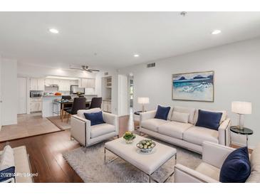 Bright and airy living room featuring hardwood floors, white furniture, and an open floor plan to the kitchen at 7777 E Main St # 258, Scottsdale, AZ 85251